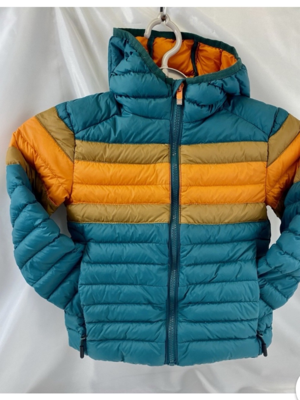 All in Motion puffer jacket featuring a teal exterior and orange lining